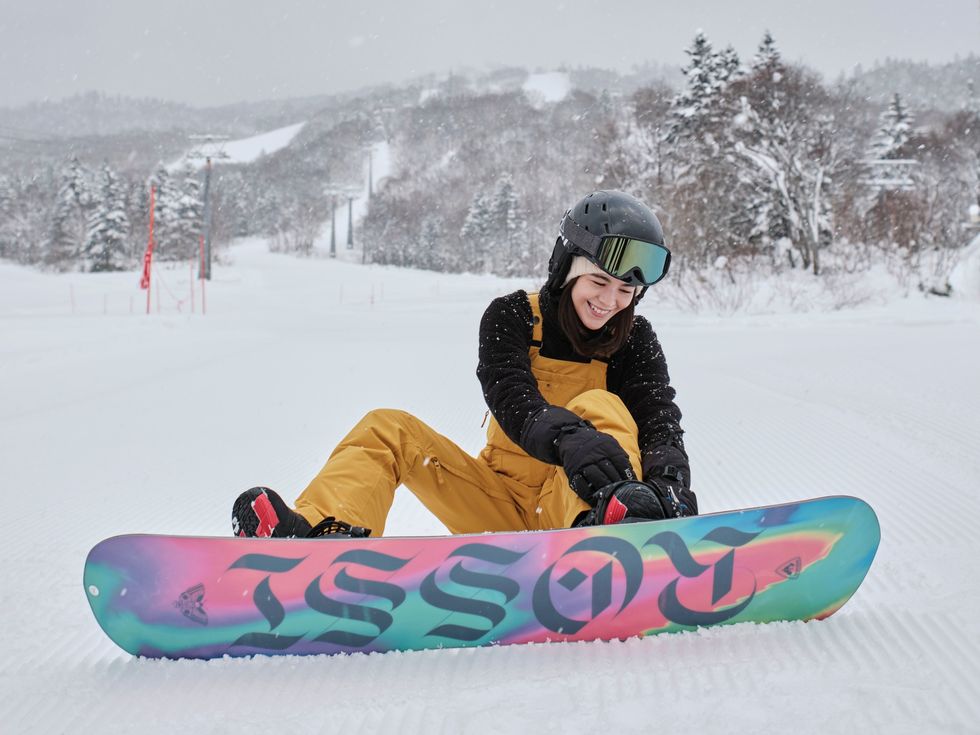 a snowboarder sitting on the snow