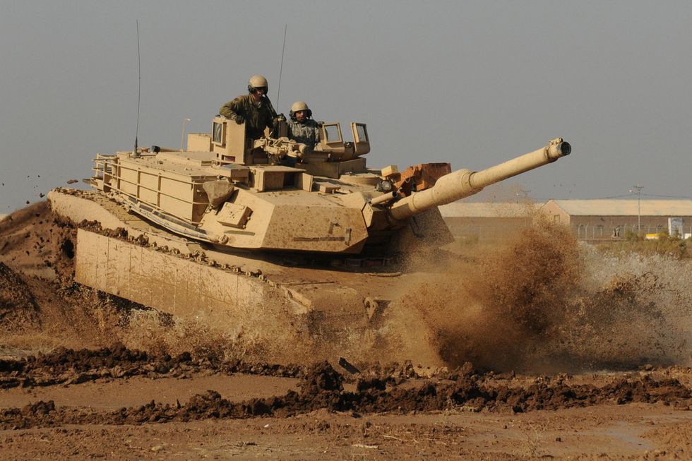 an iraqi army tanker with the 9th armored division drives an m1a1 abrams tank under the instruction of soldiers with company c, 1st battalion, 18th infantry regiment, 2nd advise and assist brigade, 1st infantry division, united states division center jan 16 at camp taji, iraq the ia tankers are preparing for a 45 day new equipment operator’s course this spring at the besmaya combat training center, iraq us army photo by sgt chad menegay, 196th mpad, 25th inf div, usd c
