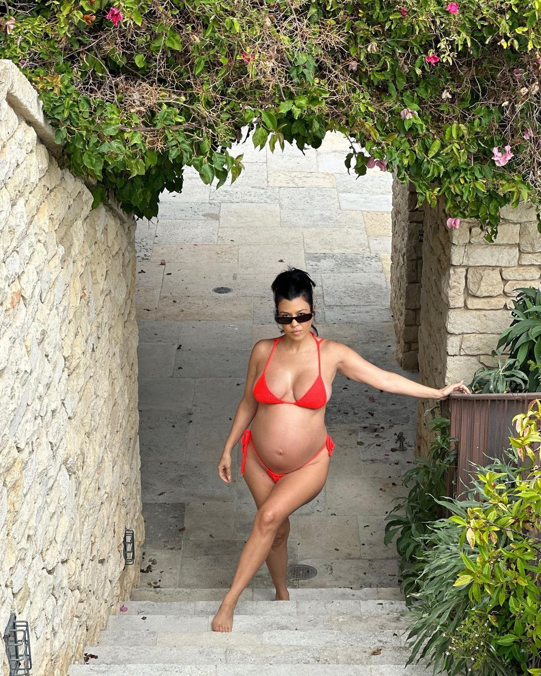 Pregnant Kourtney Kardashian Cradles Baby Bump in Red Bikini