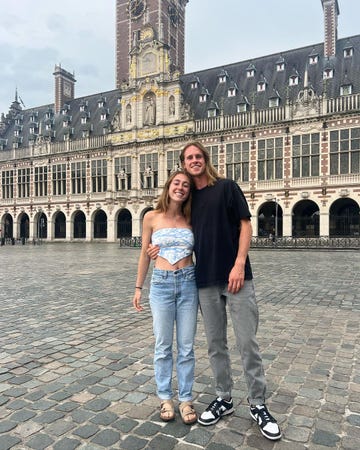 a man and woman posing in front of a building