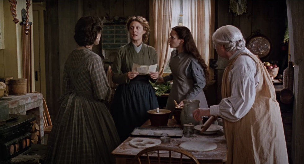 Four women engaged in a conversation in a rustic kitchen