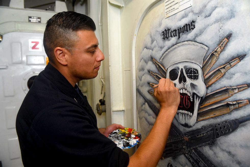 171116 n ow182 0050 pacific ocean nov 6, 2017 fire controlman 1st class juan morales, from orange county, calif, paints a mural on a door aboard the arleigh burke class guided missile destroyer uss kidd ddg 100 kidd is part of nimitz carrier strike group on a regularly scheduled deployment in the 7th fleet area of responsibility in support o maritime security operations and theater security cooperation efforts the us pacific fleet has patrolled the indo pacific routinely for more than 70 years promoting regional security, stability, and prosperity us navy photo by mass communication specialist 2nd class jacob m milhamreleased