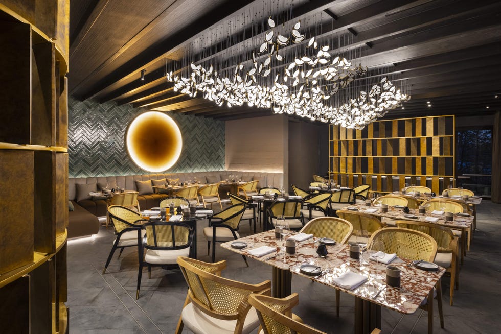 Interior of a contemporary restaurant featuring modern furnishings and decorative lighting.