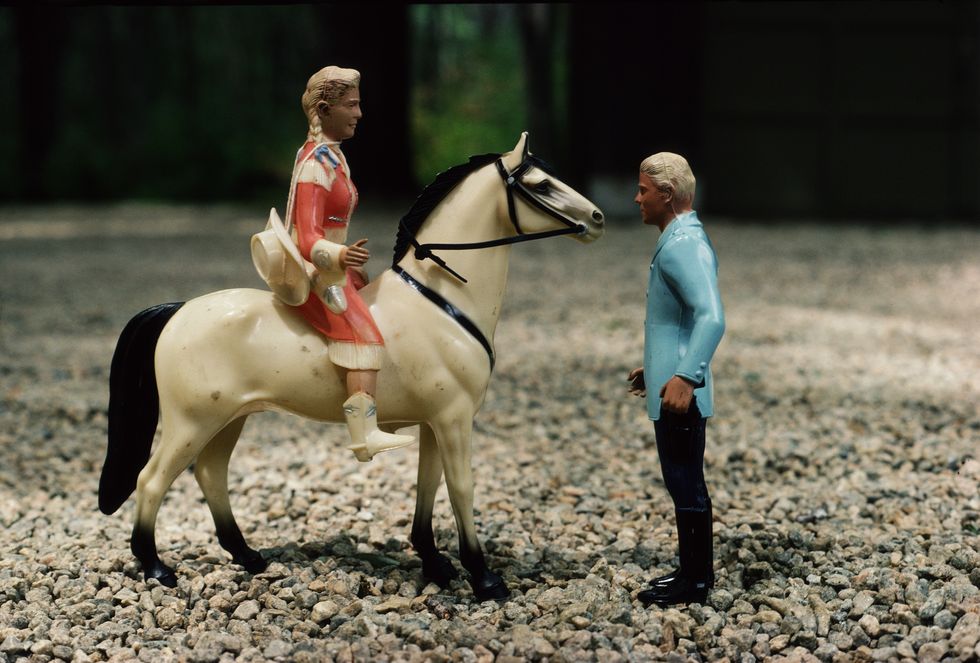 figurines of a man and a woman riding a horse