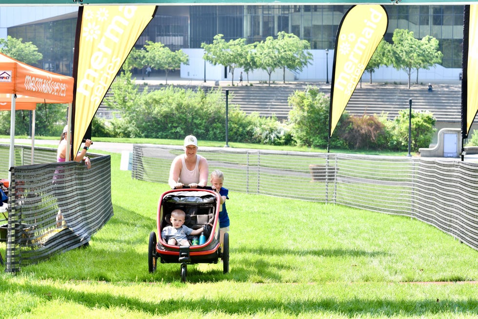 a person pushing a stroller with two children in a park event setting mermaid run spokane washington