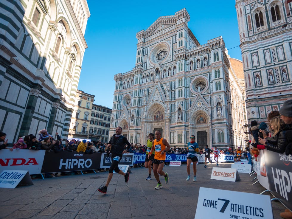 marathon runners competing in front of a historic building