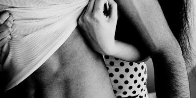 couple in black and white filter focus undressing each other man in white tshirt woman in polka dot dress