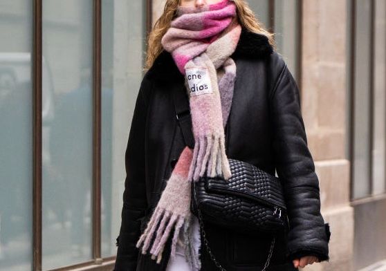 paris, france   february 27 a guest, wearing a black jacket, white pants, acne studios scarf and black bag, is seen outside isabel marant, during paris fashion week   womenswear fallwinter 20202021  day four on february 27, 2020 in paris, france photo by claudio laveniagetty images