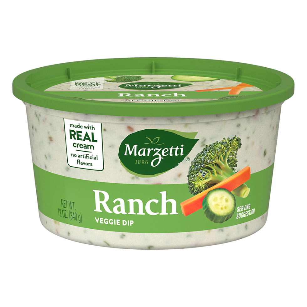 a round plastic container of ranch veggie dip featuring a green lid