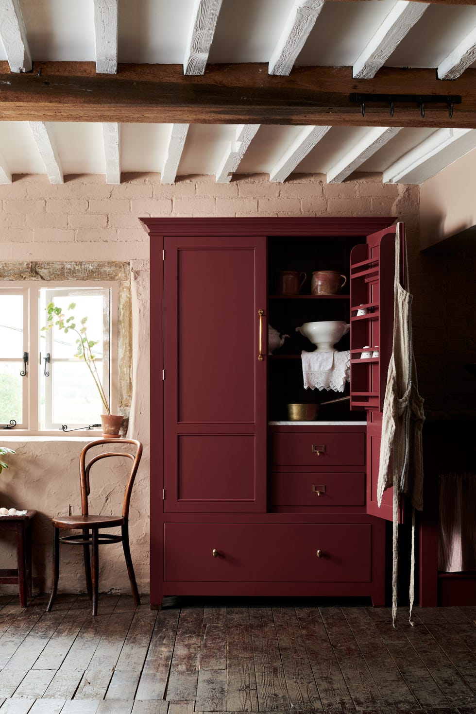 red cupboard acting as a storage unit in farmhouse kitchen