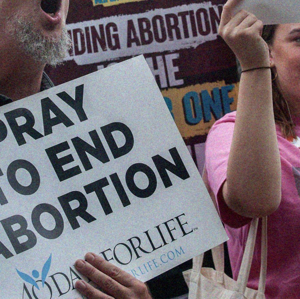 a man and woman holding a sign that protests against abortion