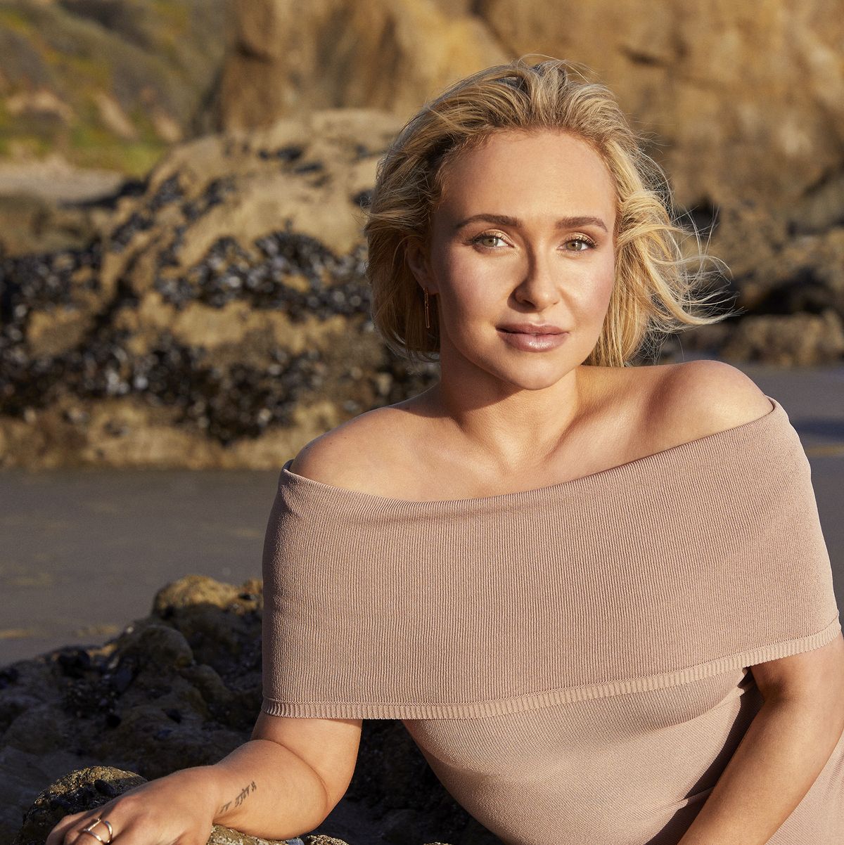 celebrity hayden panettiere laying down on the beach in nude bodysuit, looking at the camera