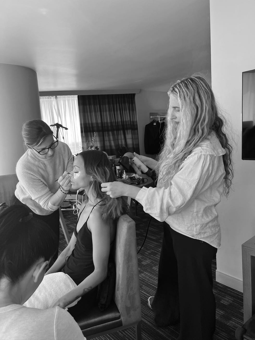 a beauty preparation scene featuring hairstylists working on a models hair