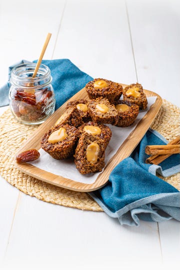baked goods served on a wooden platter with a jar of dates