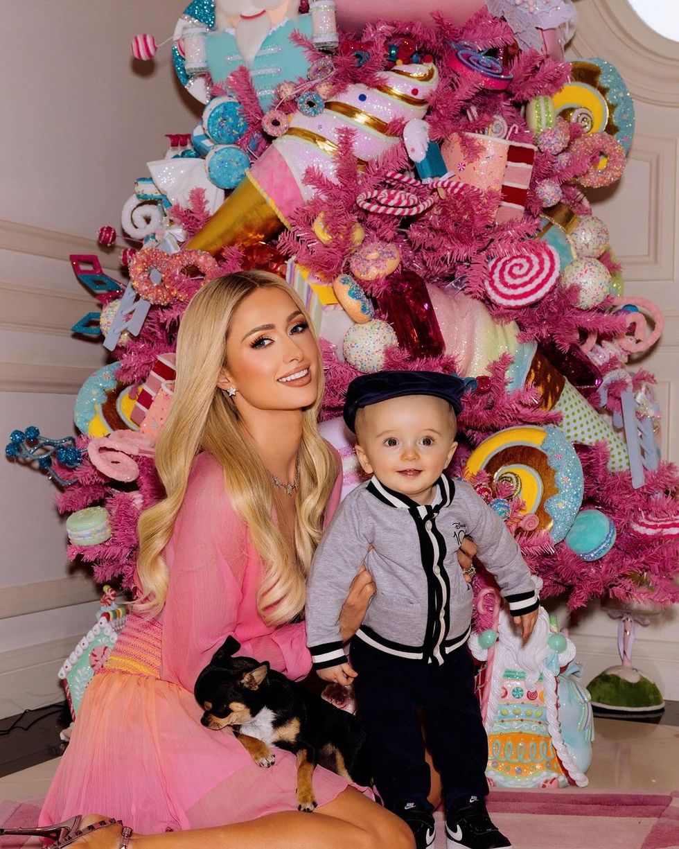a person and a boy posing for a picture with a christmas tree in the background, paris hilton and her son phoenix