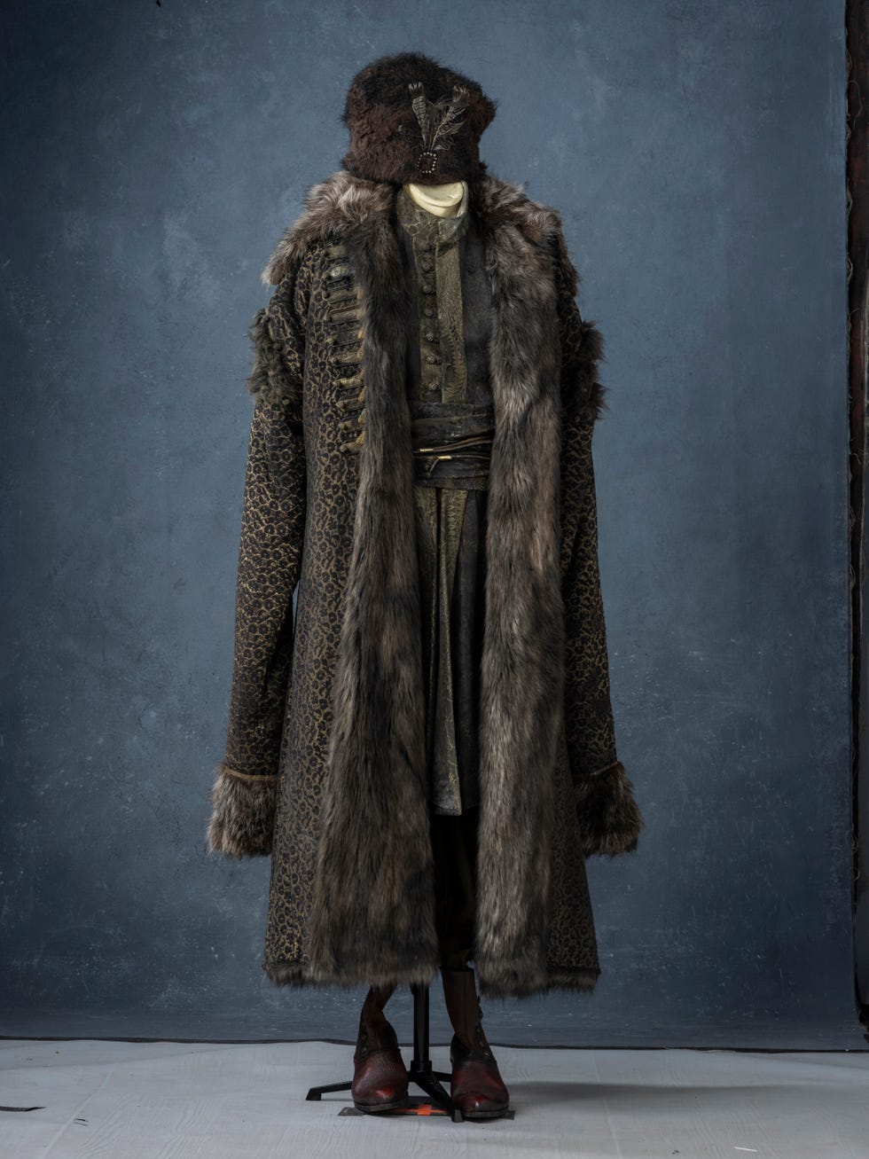 Costume featuring a fur coat and hat displayed on a mannequin