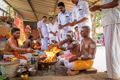 In de Amma Mandapamtempel in Tiruchirappalli ontvangt een familie zegeningen van een geestelijke Met het ritueel eren ze hun overleden moeder