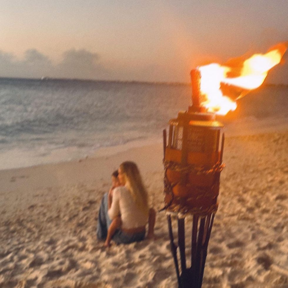 gigi hadid and khai sitting on a beach