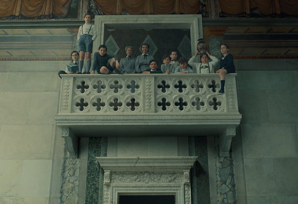 Children sitting on a balcony in an ornate room