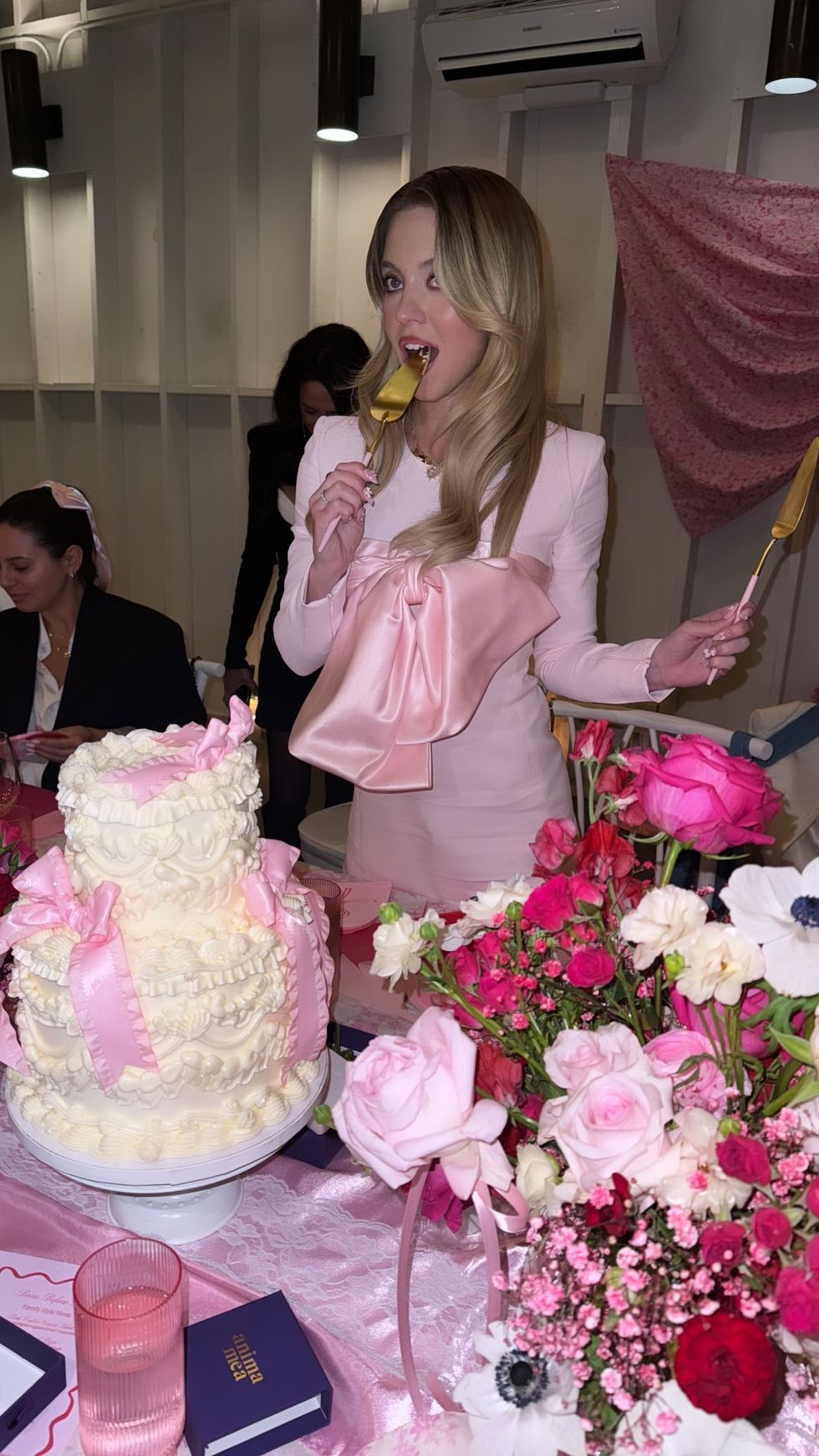 A person in a wedding dress holds a knife and cake