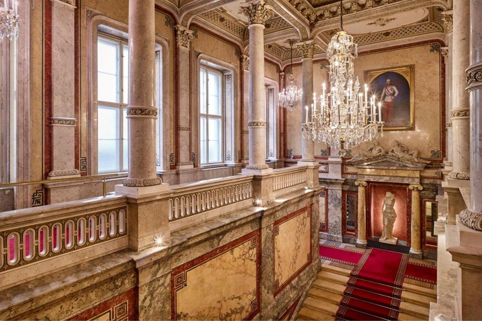 a large ornate room with a chandelier and a staircase