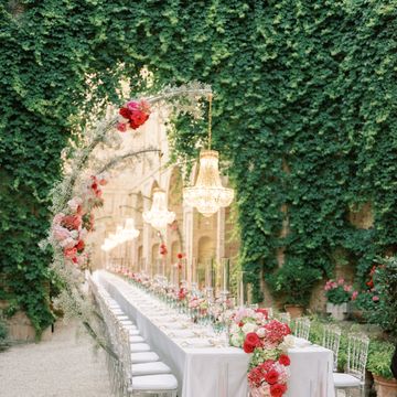 a long white table with flowers on it and a white table with a gold crown and a gold