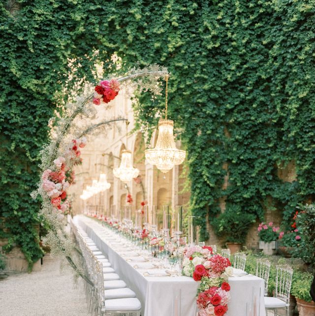 a long white table with flowers on it and a white table with a gold crown and a gold