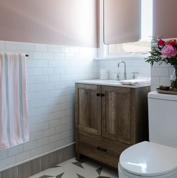 pink bathroom, white subway tiles, dusty pink painted walls, wooden bathroom cabinets, silver faucets