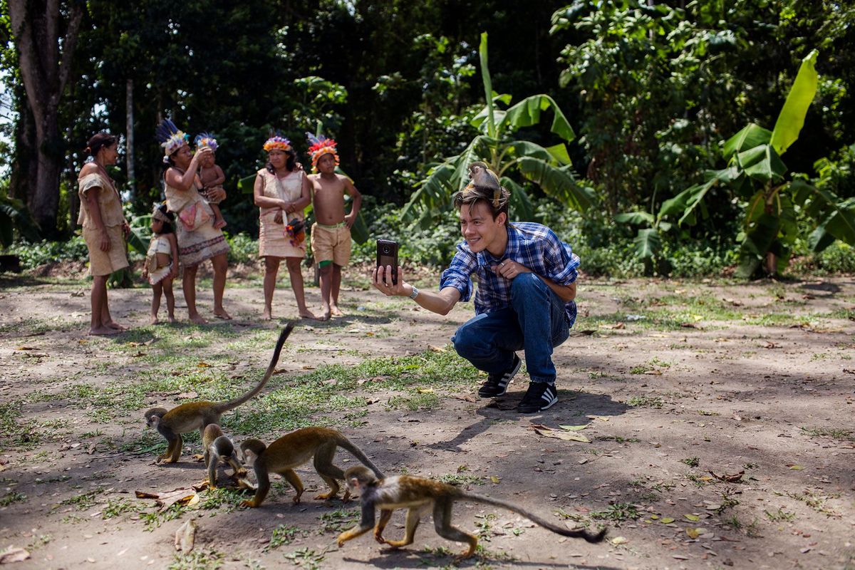 Een jongeman maakt een selfie op het Isla de los Micos Apeneiland in het Colombiaanse Amazonegebied In de regio is het fenomeen van de selfiesafari waarbij toeristen wilde dieren kunnen vasthouden en ermee op de foto kunnen gaan in opmars Dierenexperts zeggen dat veel van deze wilde dieren buiten het zicht van de toeristen worden mishandeld
