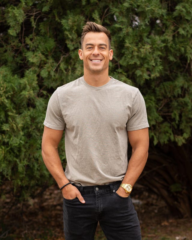 a man standing in front of a forest