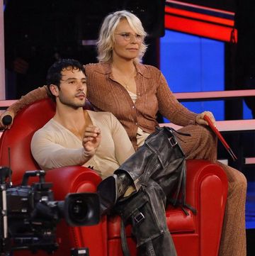 a woman sitting on a chair with a man sitting on a red chair