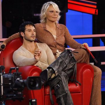 a woman sitting on a chair with a man sitting on a red chair