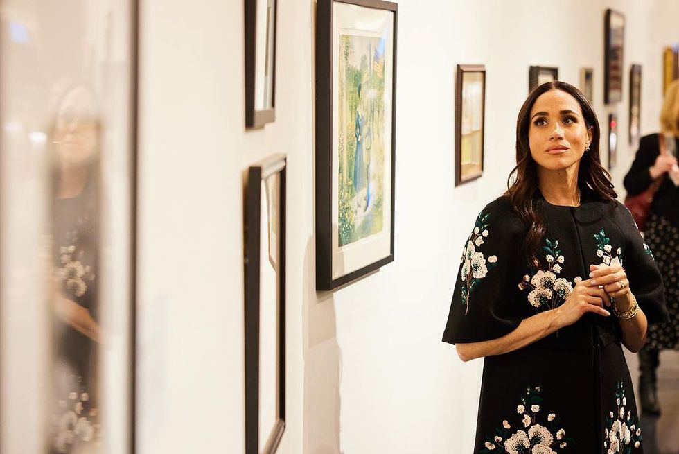a woman standing in a room with art on the wall