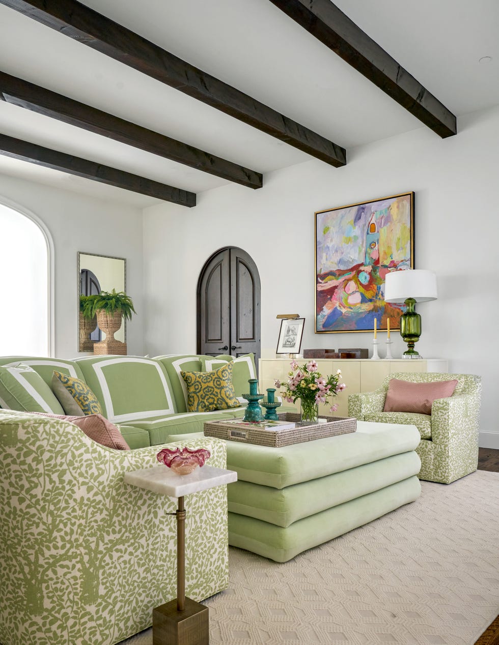 living room area with a green couch, green chairs and a green ottoman