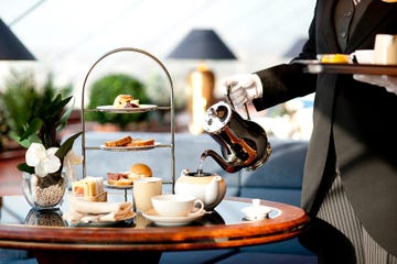 a person pouring tea into a teapot