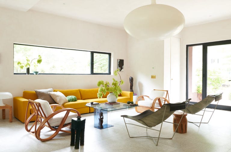 Modern living room featuring a bright yellow sofa and various seating options.