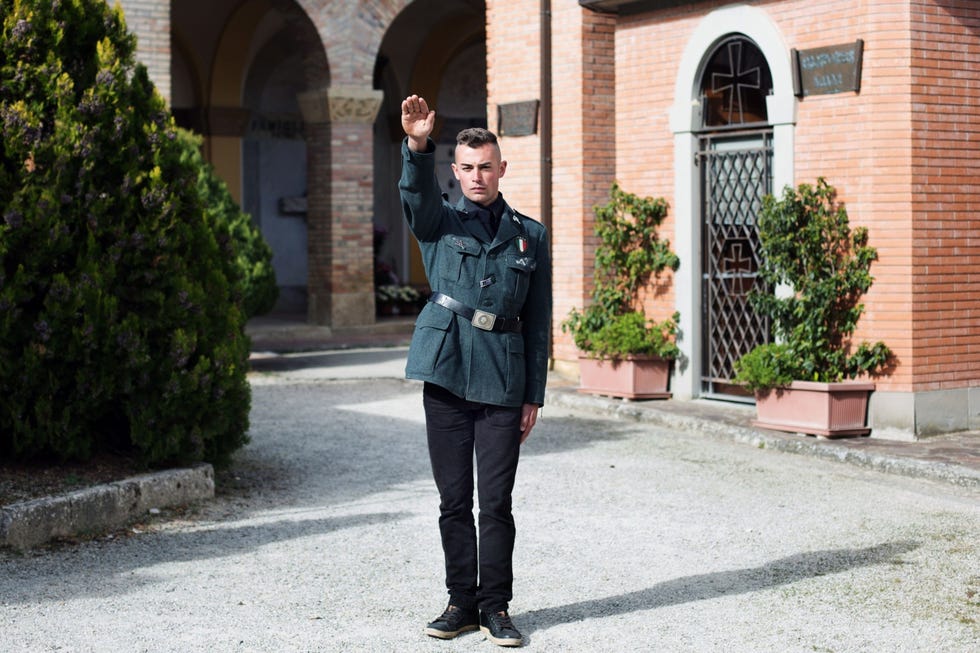 Een hedendaagse aanhanger van het Italiaanse fascisme brengt de fascistengroet in de buurt van de crypte van de familieMussolini op het Cimitero Monumentale van San Cassiano in Pennino