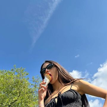 olivia rodrigo wearing sunglasses and eating ice cream
