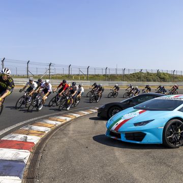 a group of people riding bikes next to a race car