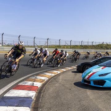a group of people riding bikes next to a race car