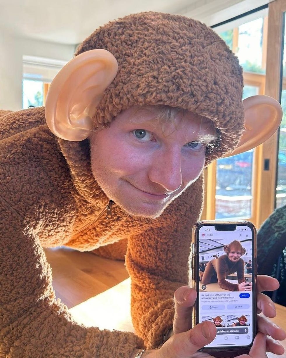 a person wearing a large monkey costume holding a phone showing a chat message