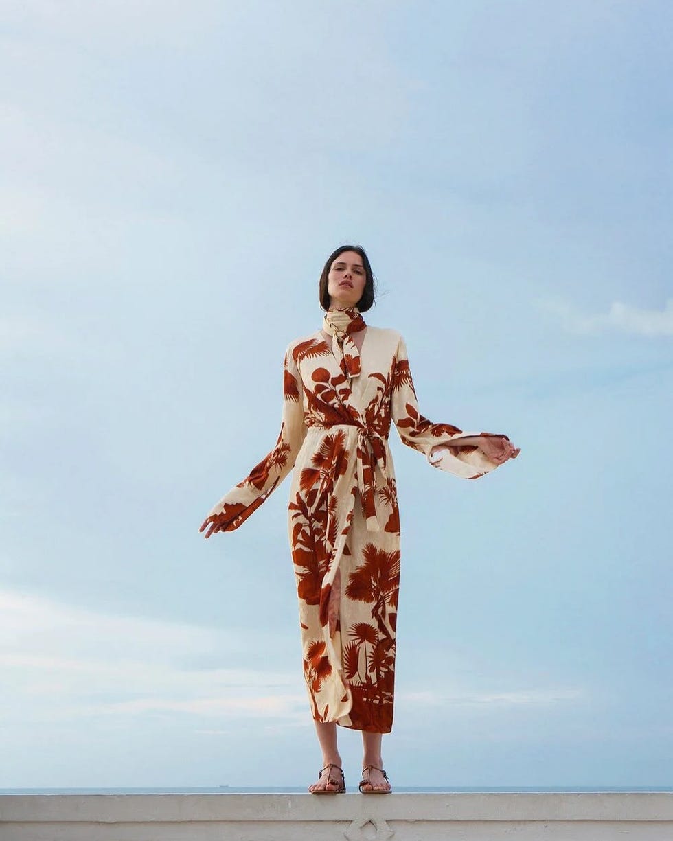 model wearing a patterned dress against a clear sky