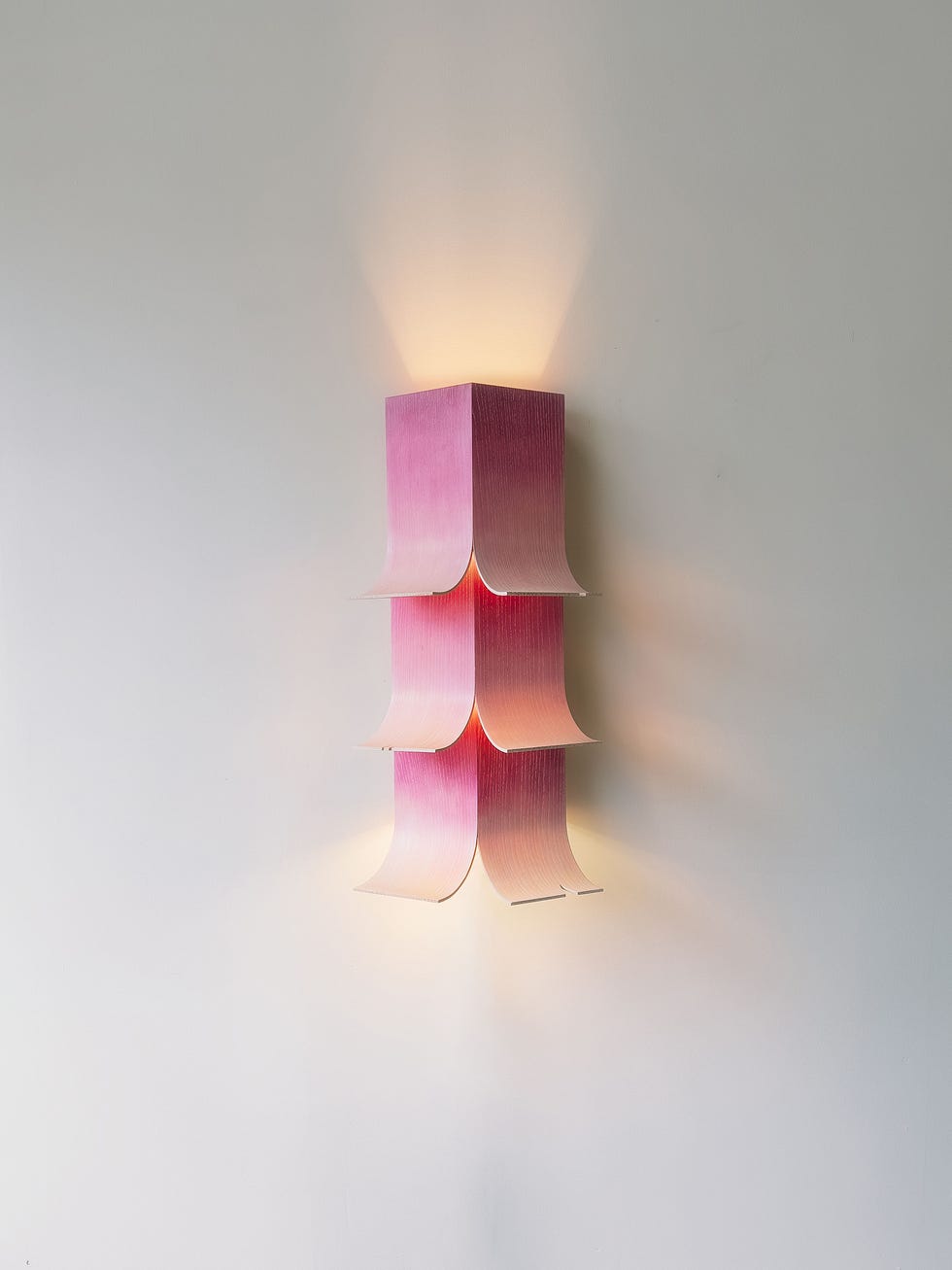 Wall-mounted light fixture with a pink design.