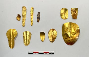 collection of gold artifacts arranged on a white background