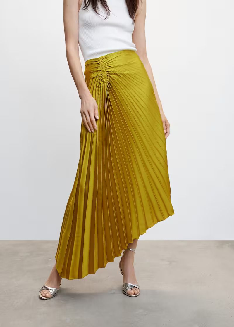 la falda amarilla plisada asimétrica midi rebajadísima de mango outlet que ha conquistado a las expertas y que ya es un best seller entre las invitadas de primavera