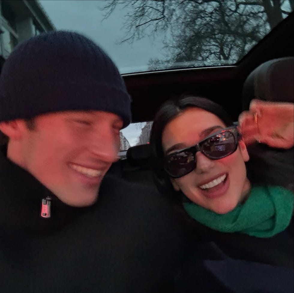 a snapshot capturing two individuals seated in a vehicle during twilight