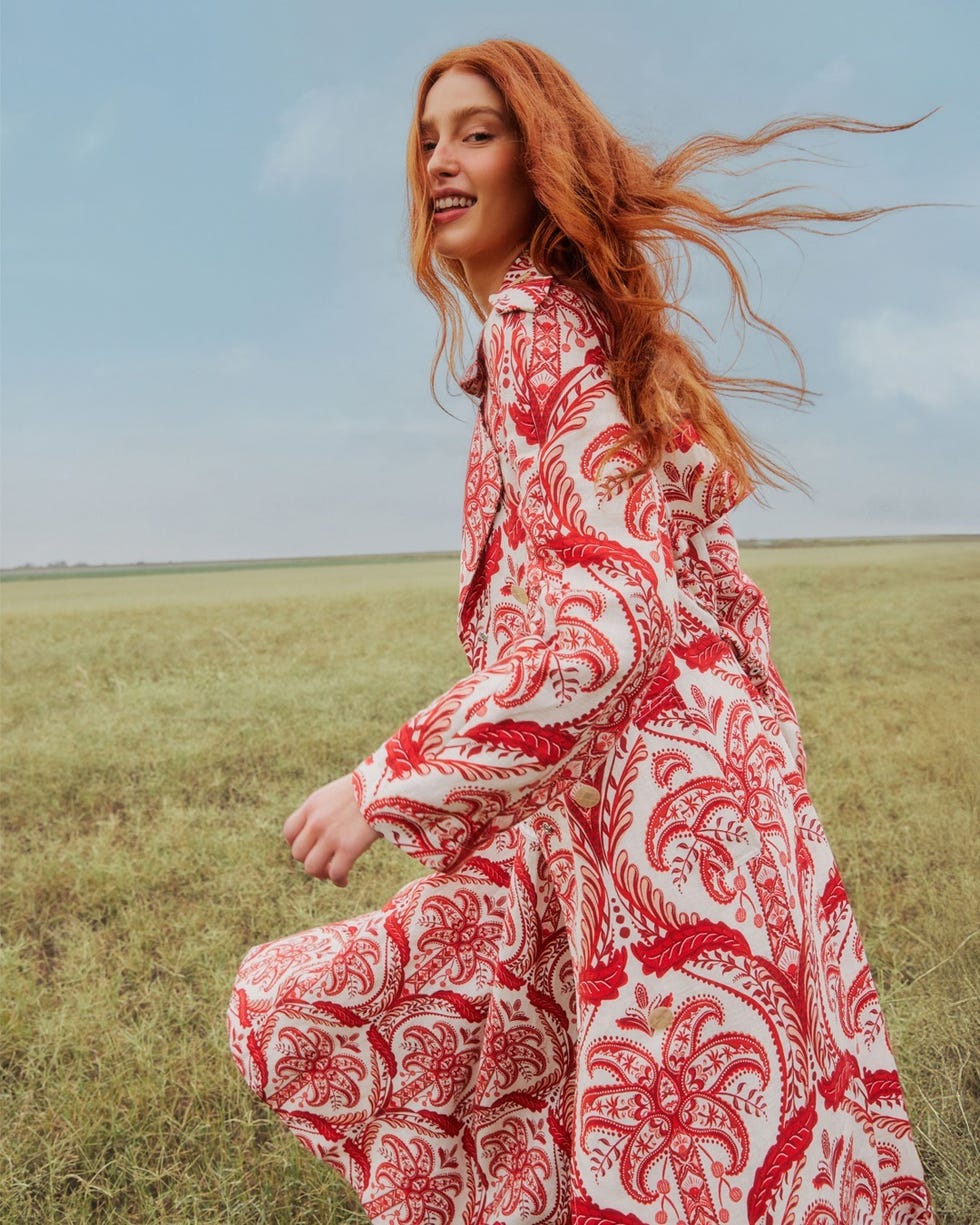 woman in a patterned dress running in a field