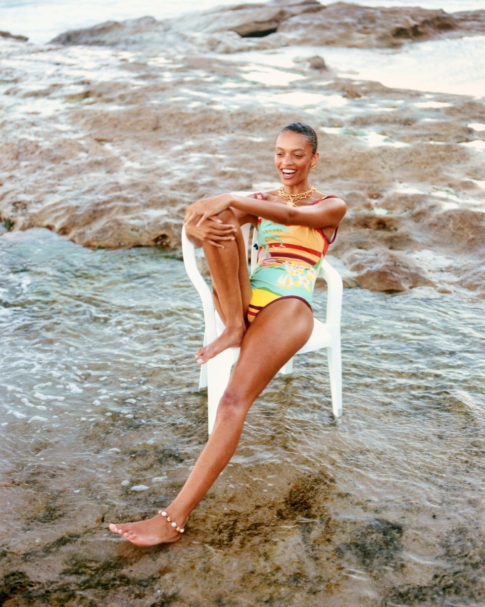 a person relaxing on a beach chair in shallow water