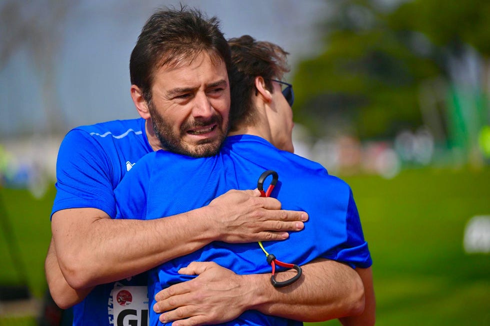 two athletes embracing in a supportive gesture