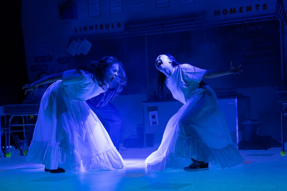 two young women wearing all white and screaming in the play john proctor is the villain